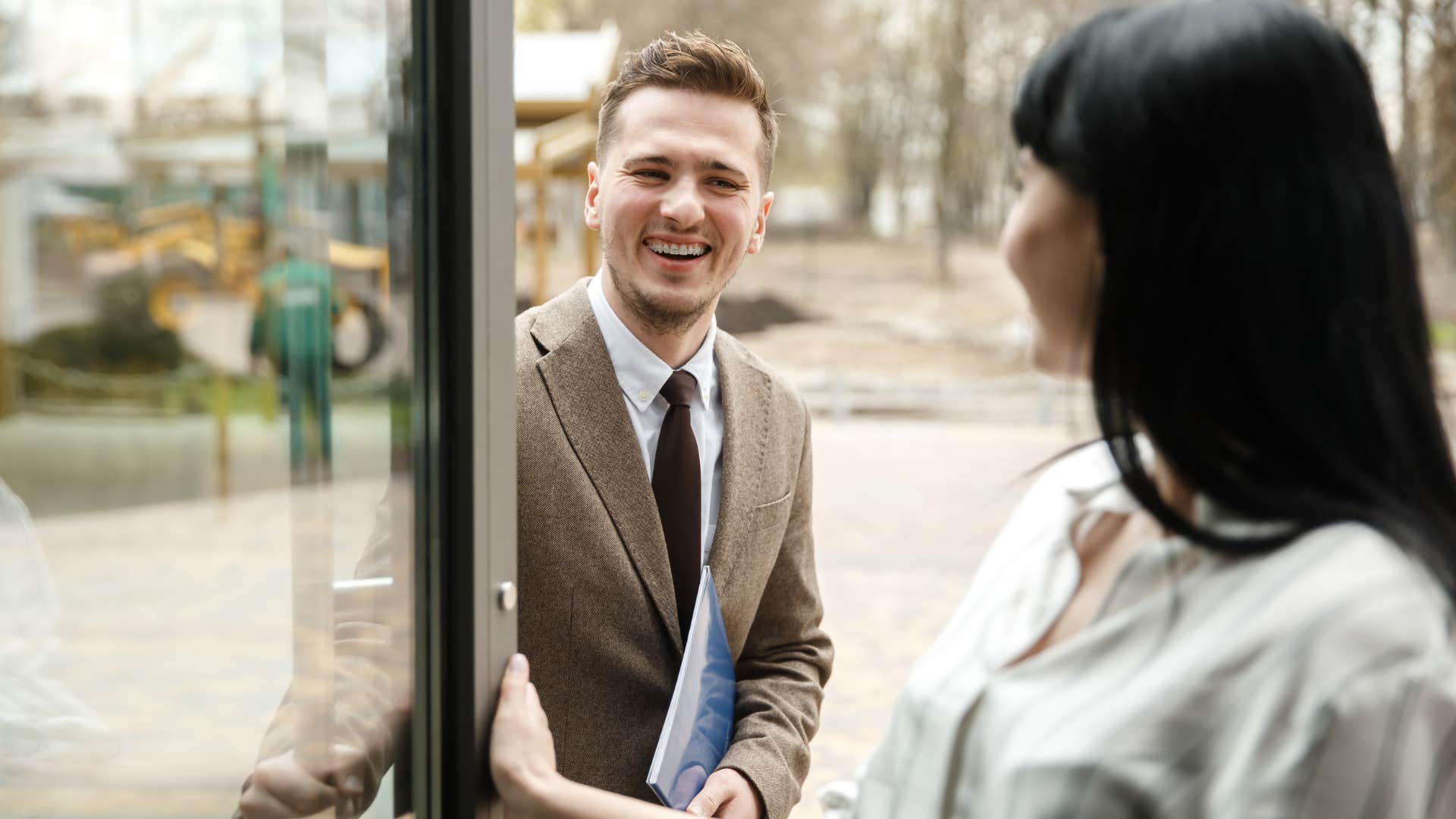normal man holding the door open for woman as a social norm