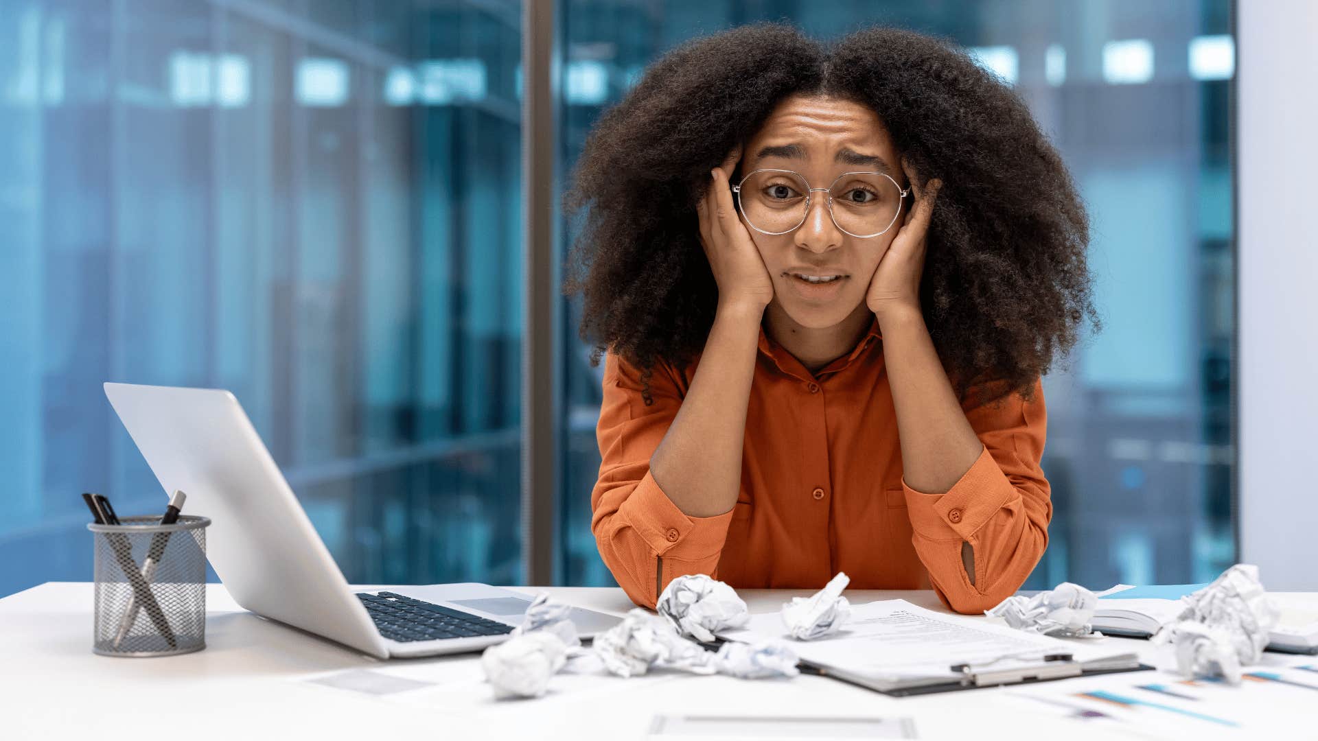 normal woman giving into hustle culture looking stressed at work