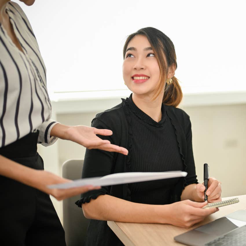 office worker being trained by boss working together in the office