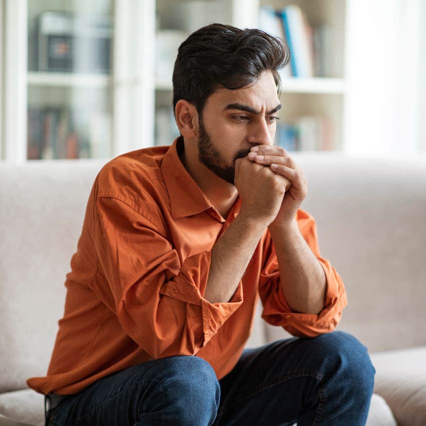 man sitting on couch worried about health risks from his birth month