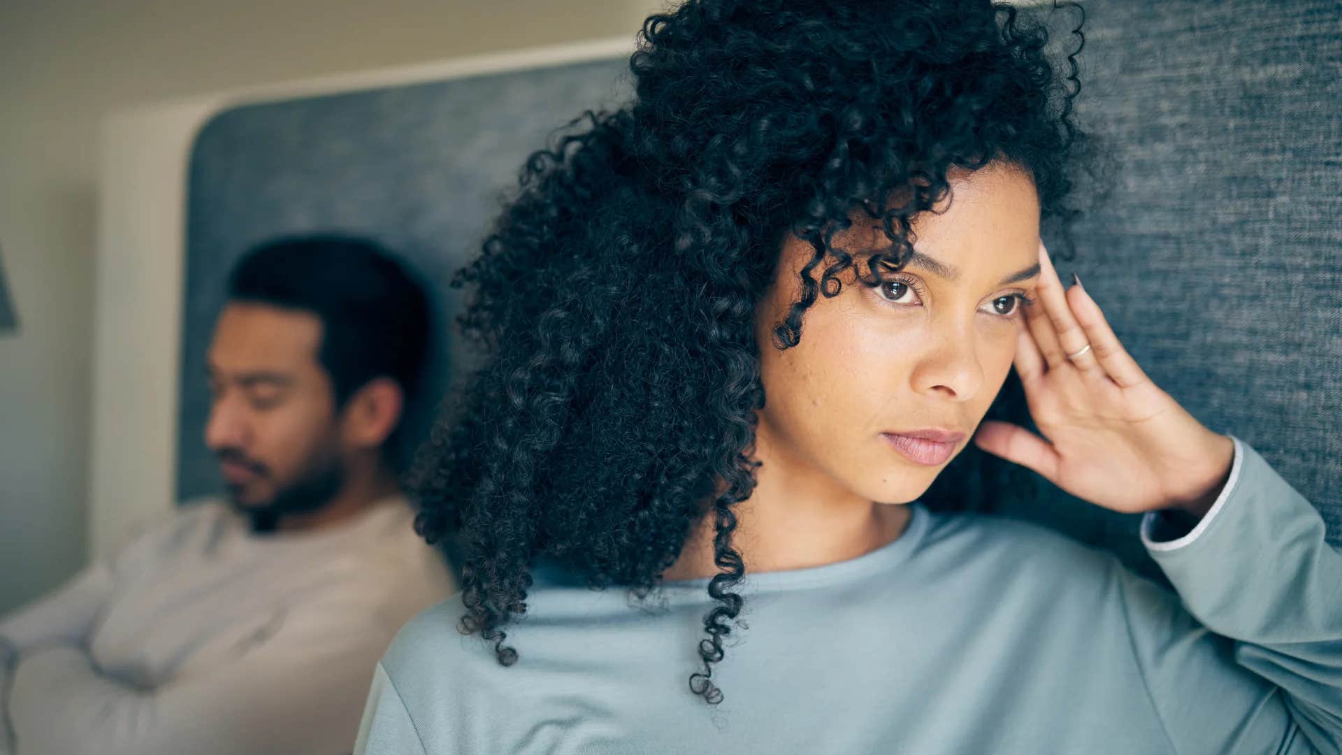 woman turned away from her upset husband about to go to sleep