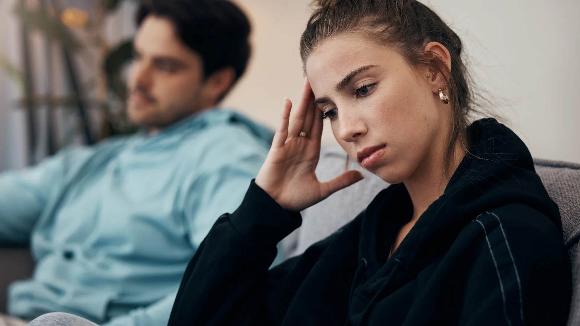 woman turned away from distracted husband annoyed they aren't spending quality time together