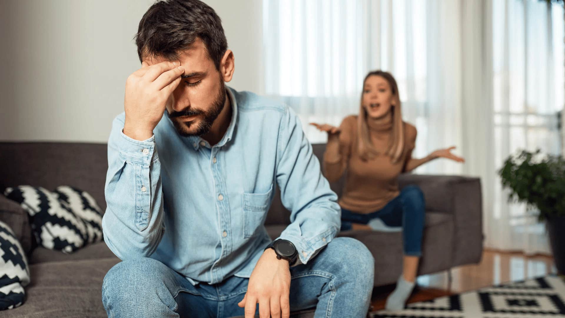 upset man turned away from his wife yelling about his lying