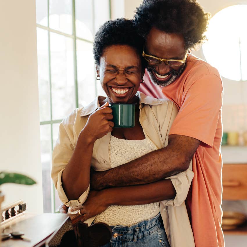 Couple in a new relationship that's going well hugging in the kitchen
