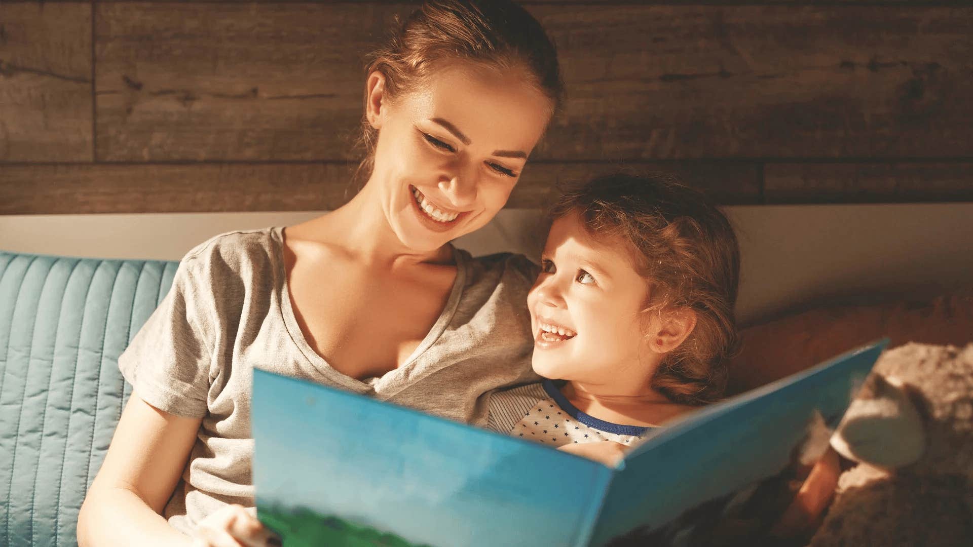 mom smiling and reading with child before bedtime