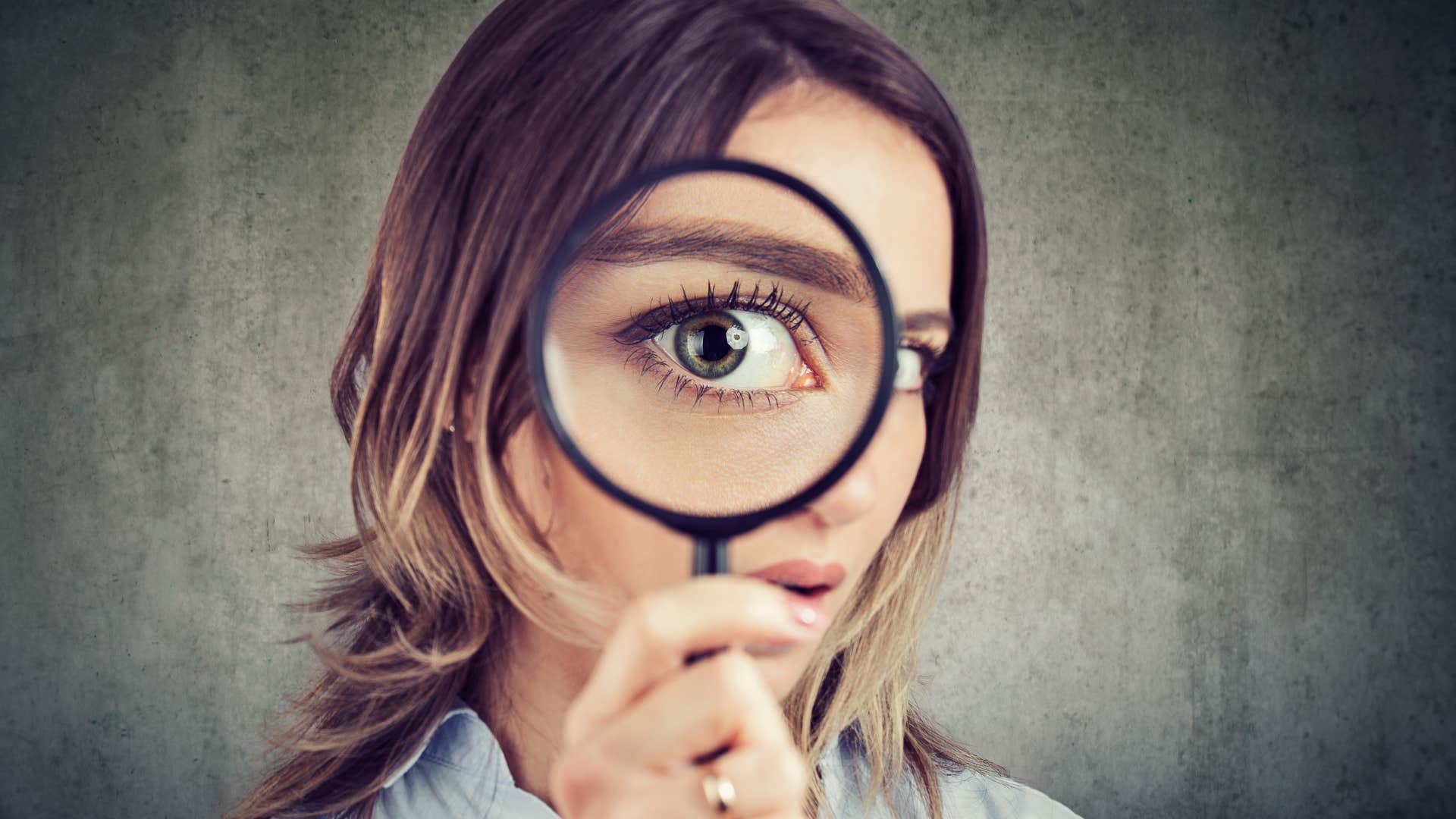 woman looking through a magnifying glass to read into subtext