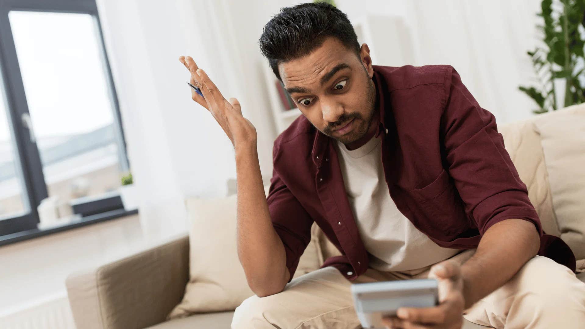 man looking at bill on phone saying i can't afford to save