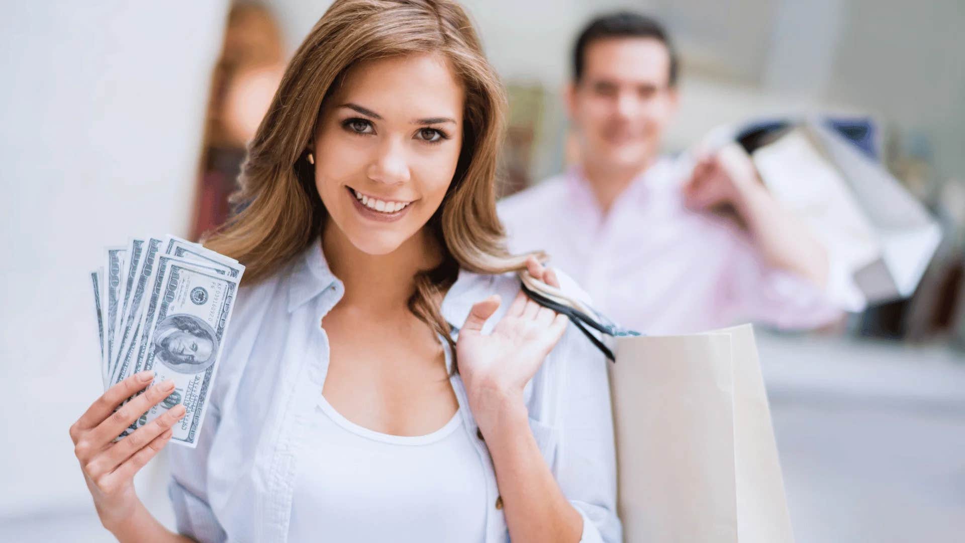 woman holding cash saying the more i make the more i spend