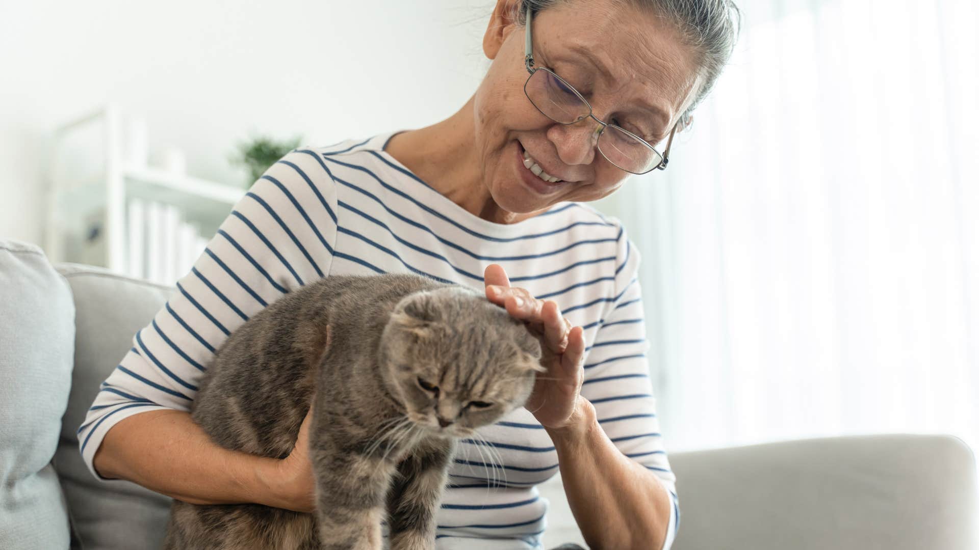older woman petting her cat checking to make sure she's okay