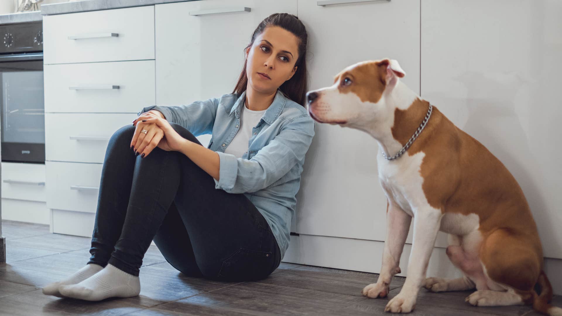 sad young woman at her parents home feeling controlled by the dog