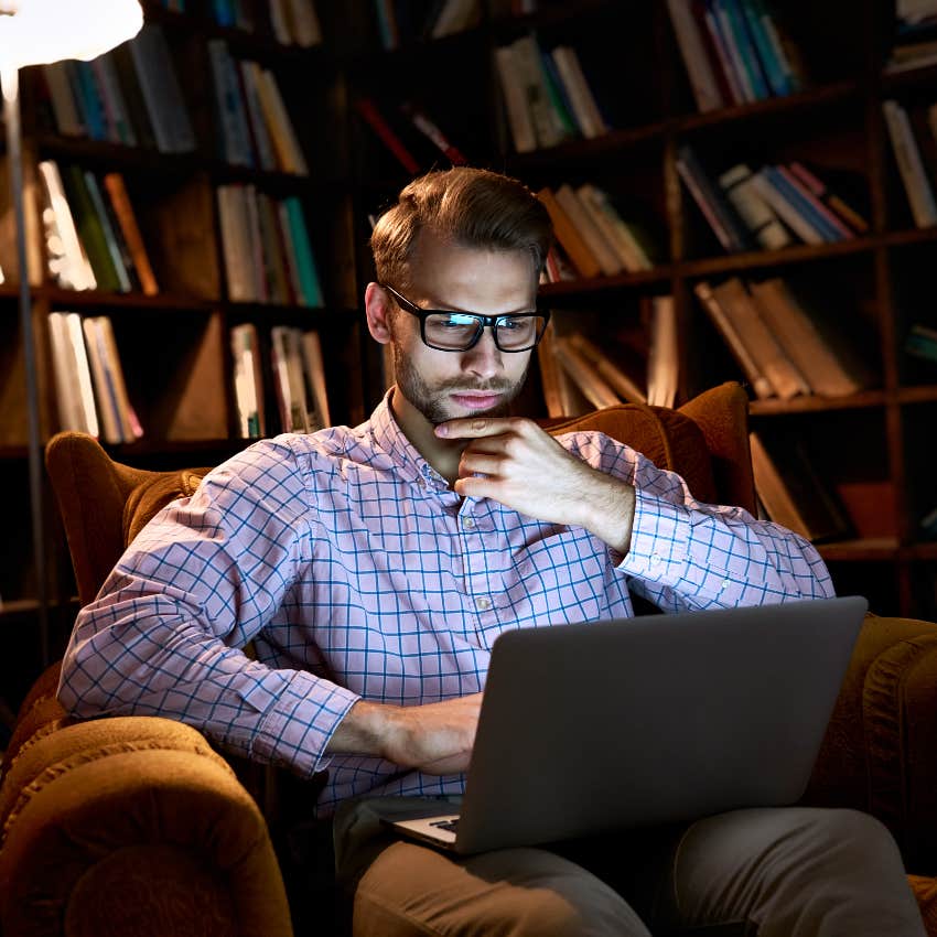 man working on computer in home library at night trying to tell if something is ai