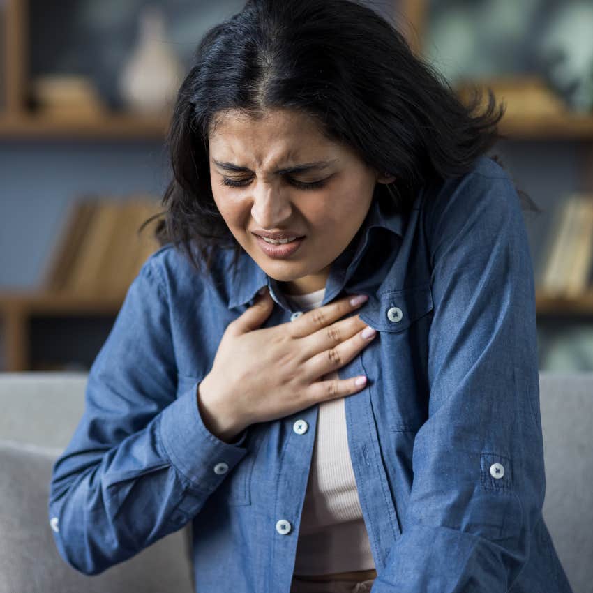 woman whose chest feels tight holding her hands to her chest