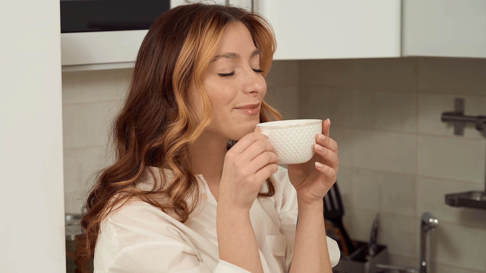 woman in a fully stocked kitchen with her favorite mug
