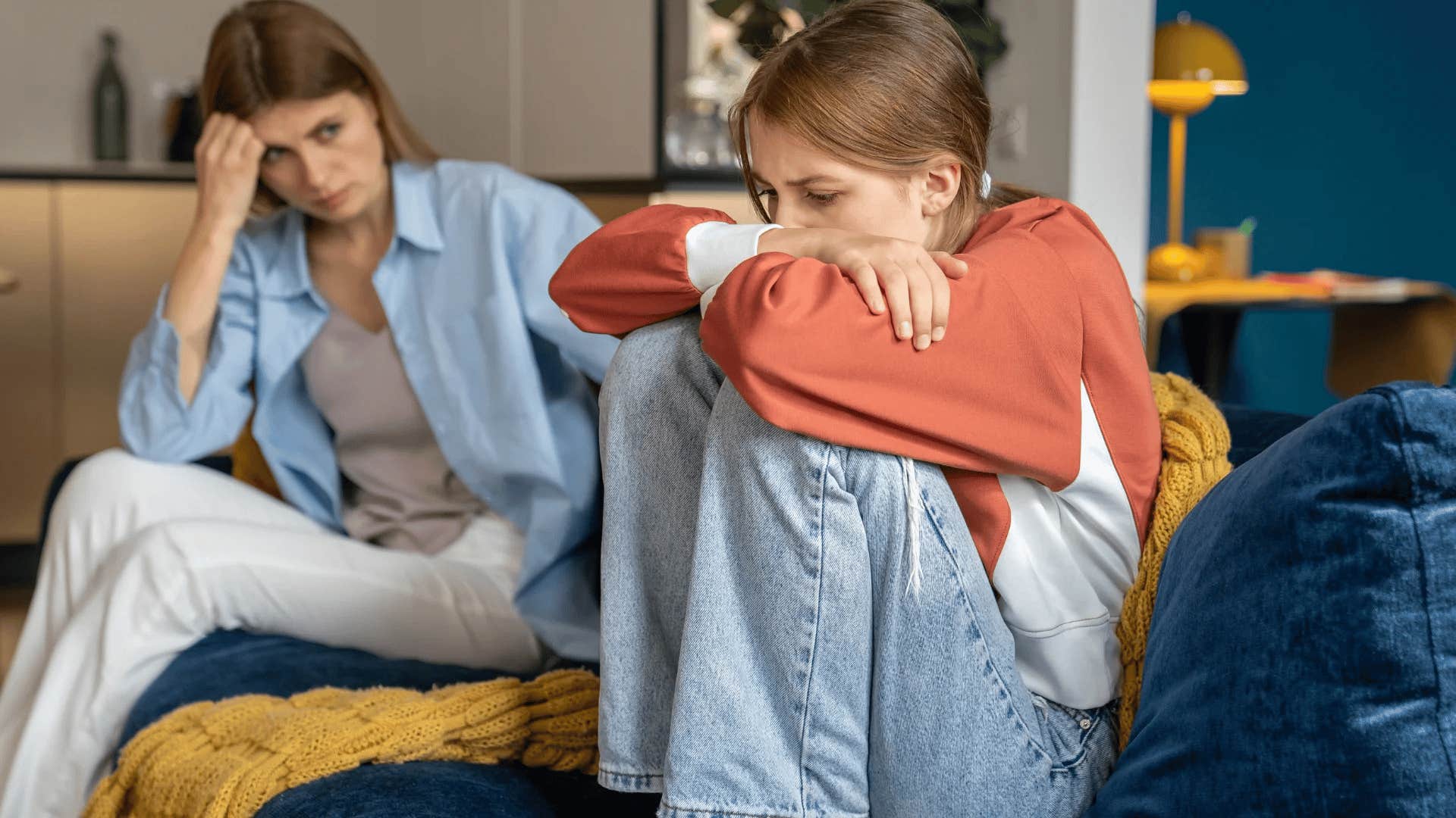 upset teen girl turned away from mom who doesn't discipline her