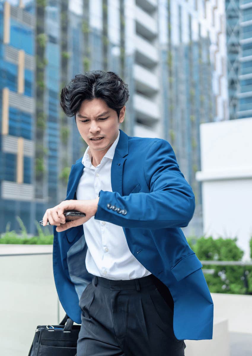 man in blazer looking at his watch running late
