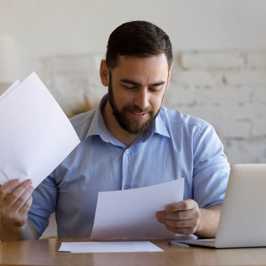 man happily paying his bills after negotiating them