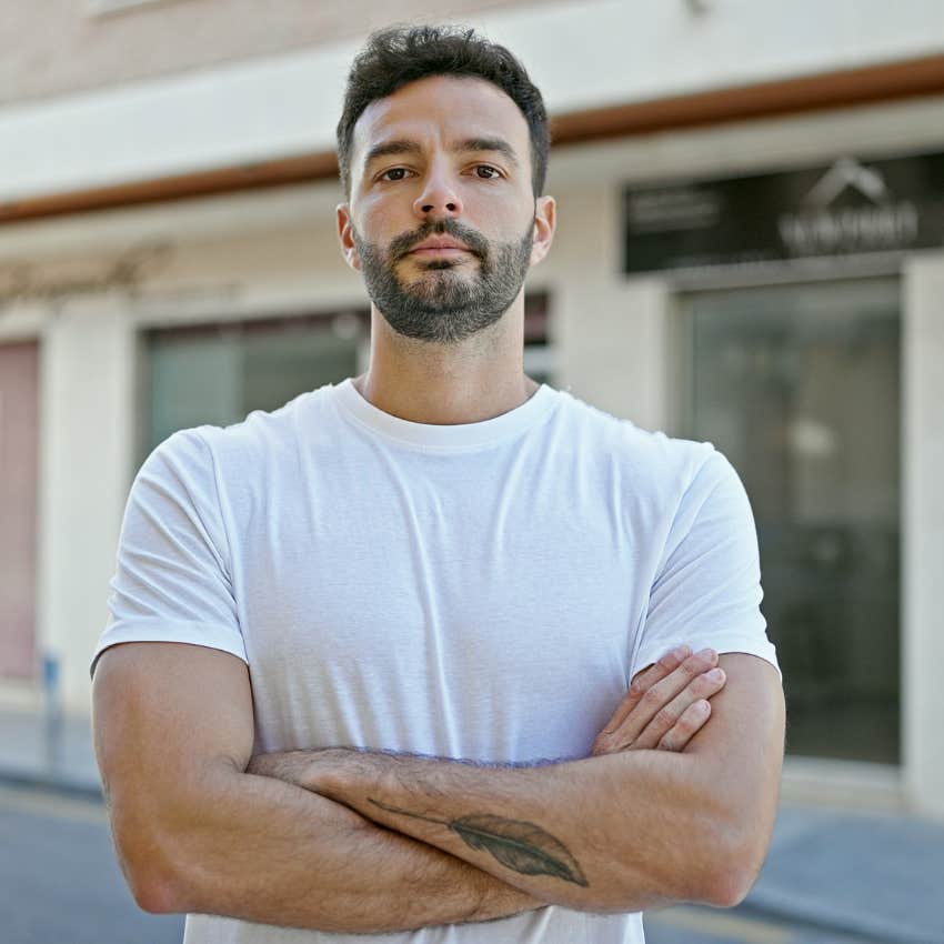man standing with arms crossed outside