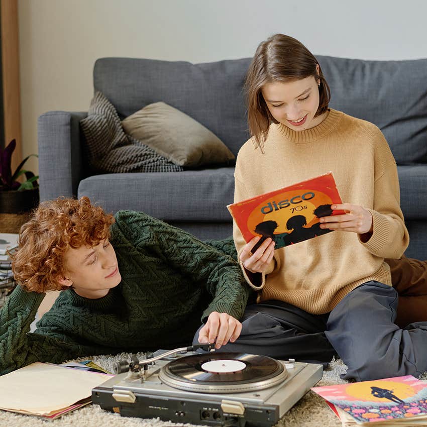 two people looking at and playing vinyl records
