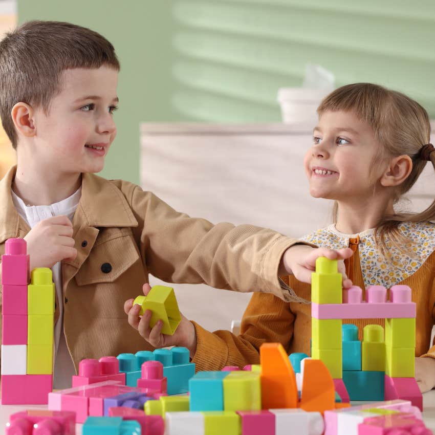 two little kids playing with blocks sharing happily