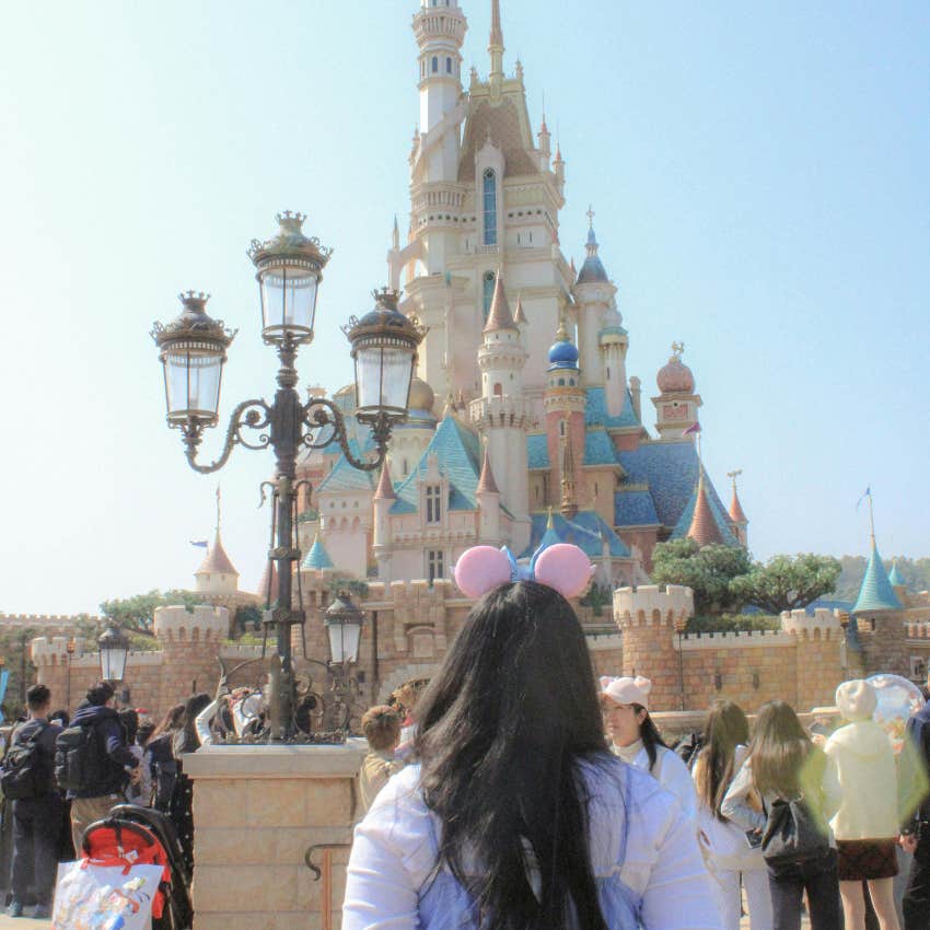adult woman looking at cinderella's castle at disney enjoying a trip to the park despite not having kids