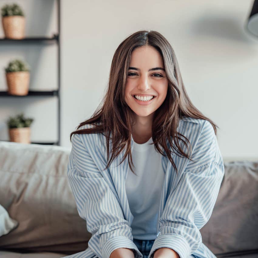 happy woman smiling sitting on couch at home