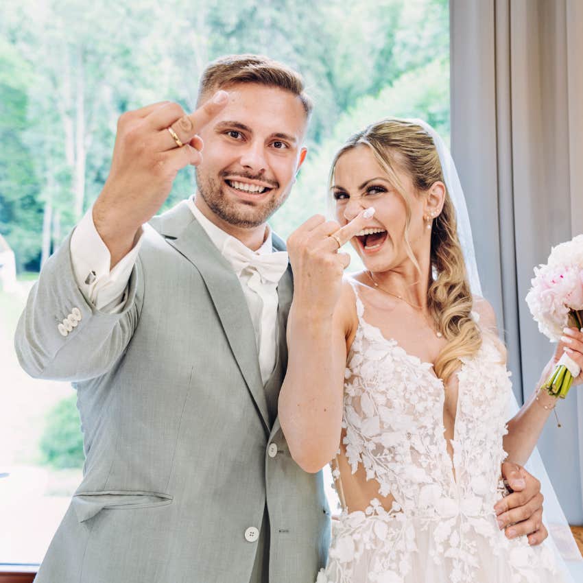 newlywed couple showing off wedding rings woman not taking husband's last name