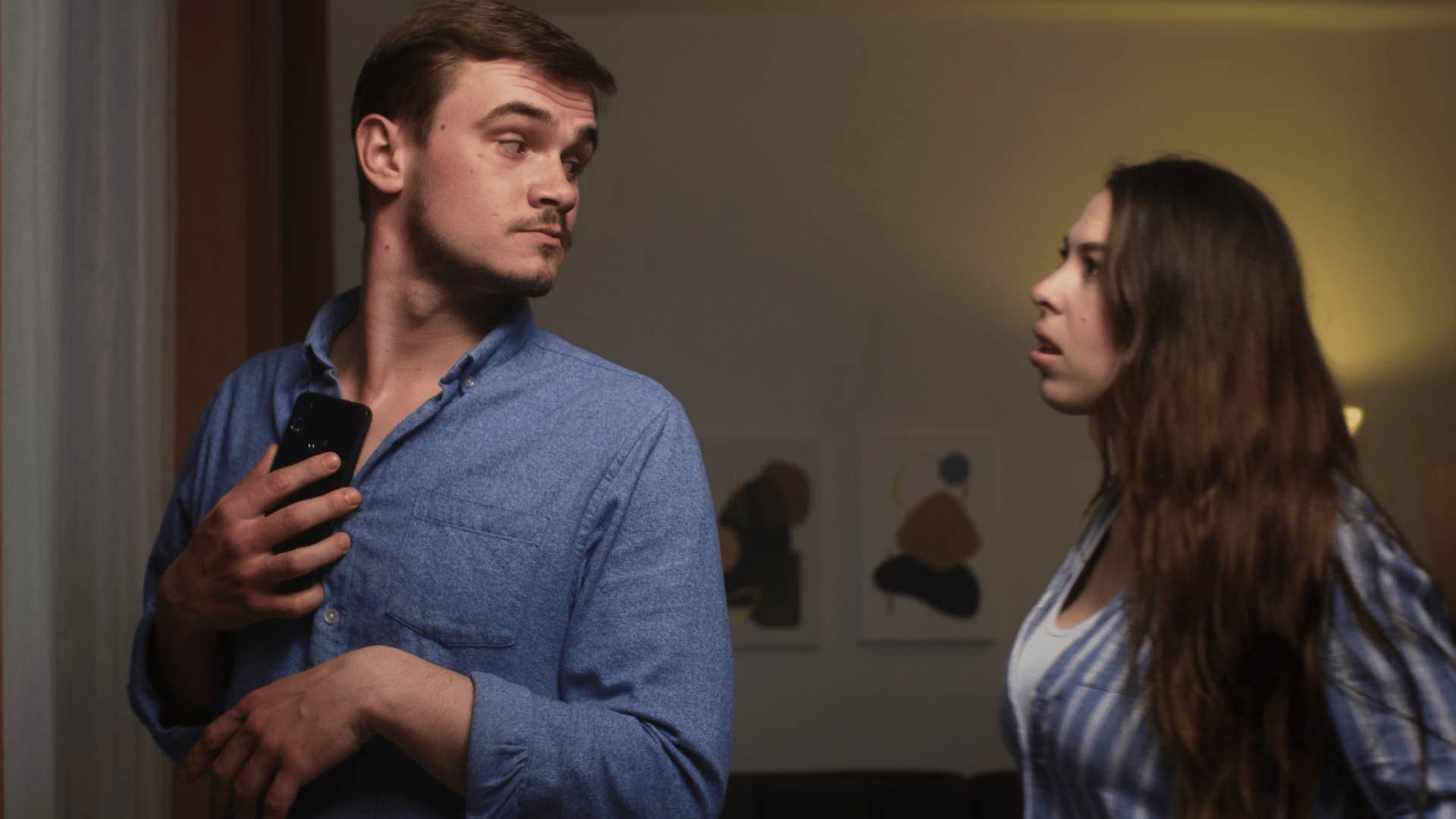 man hiding his phone being secretive with his wife