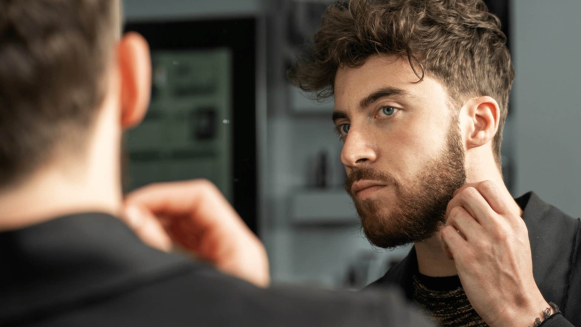 man spending a lot of time on his appearance getting ready in mirror