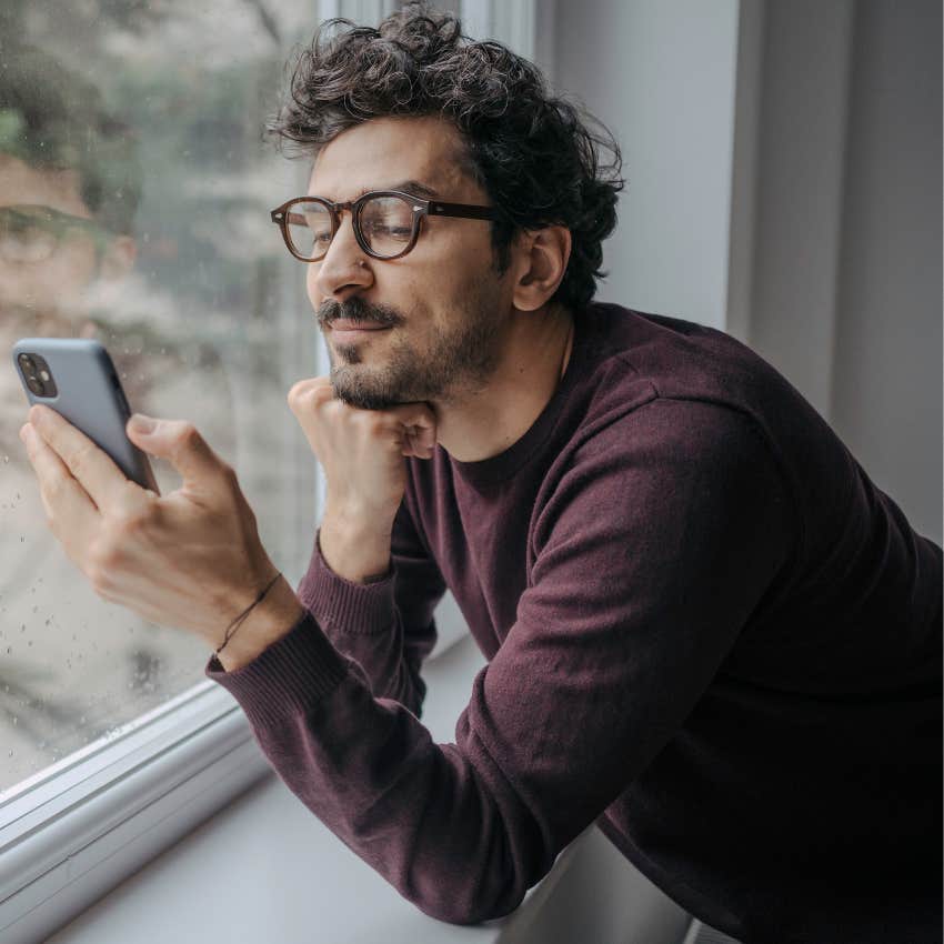 happy man looking at phone excited at canceled plans