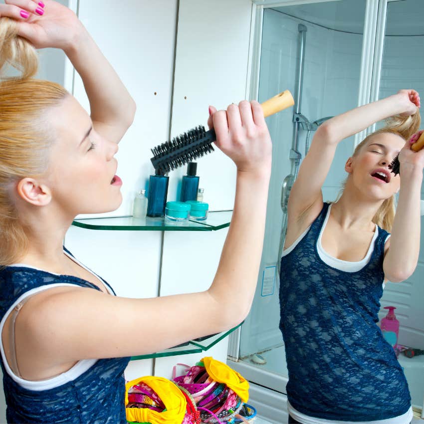 teen girl lip-syncing in the mirror to entertain herself