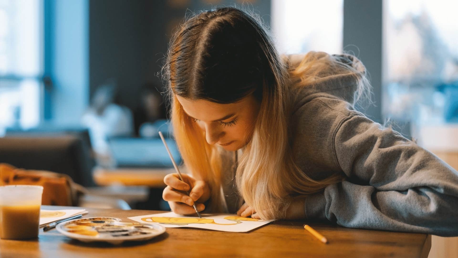 teenager painting a handmade school project