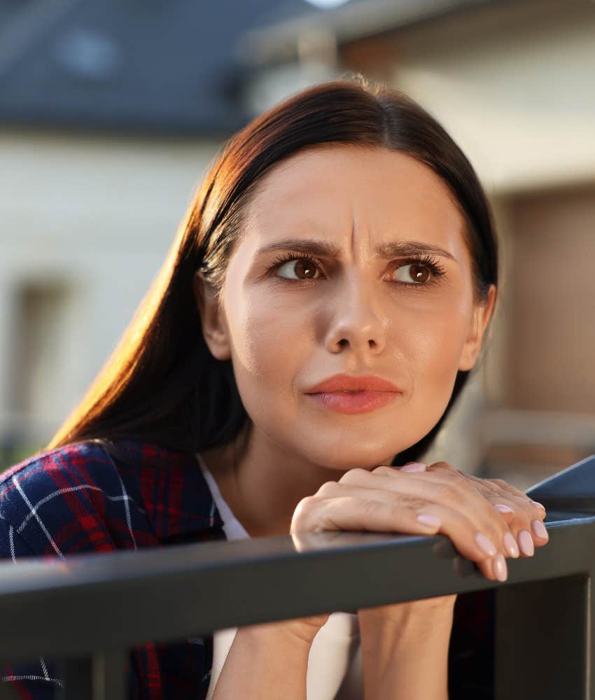 distrusting person leans over rail to look and listen