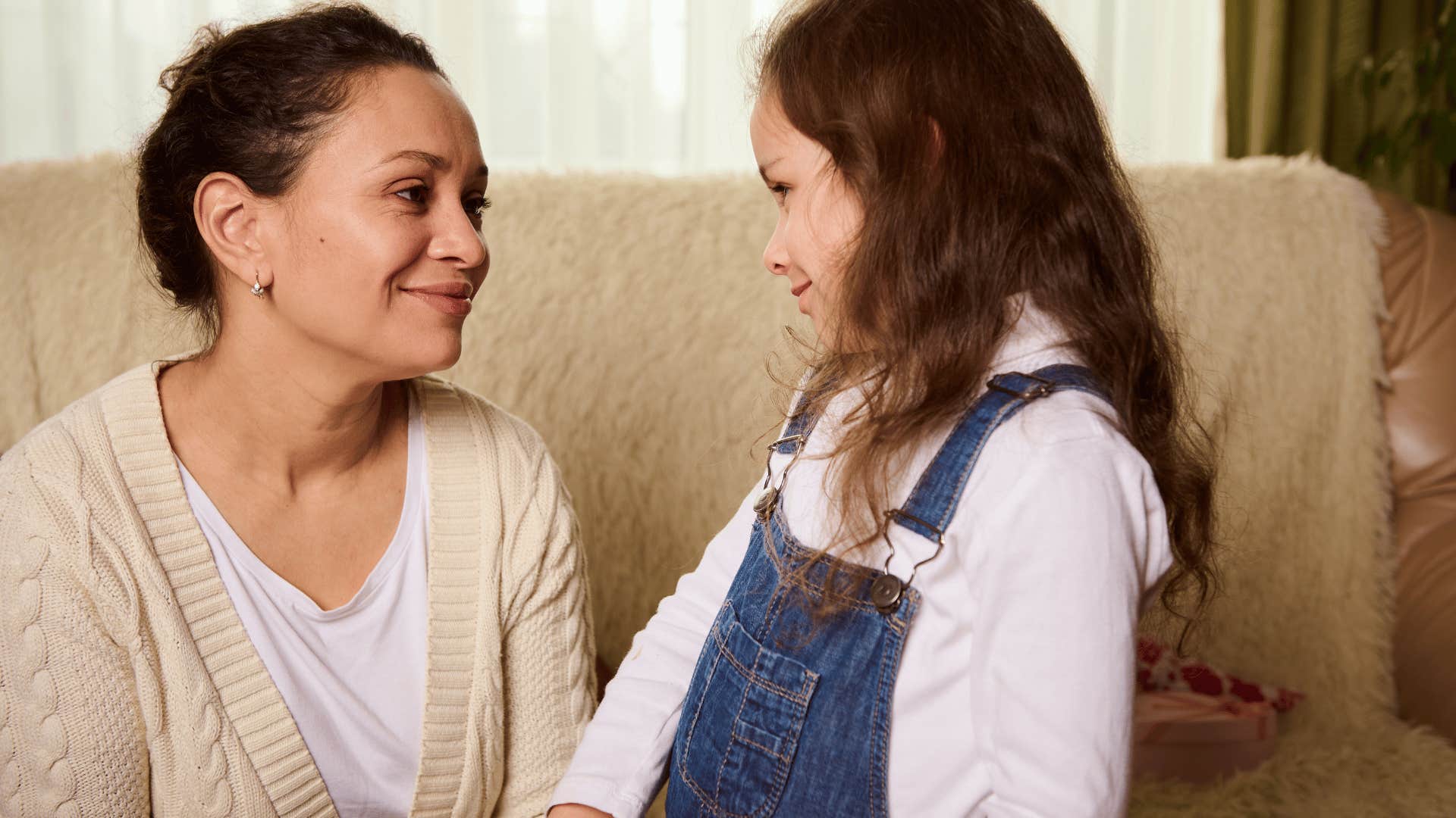 smiling mom telling daughter don't worry about saying thank you