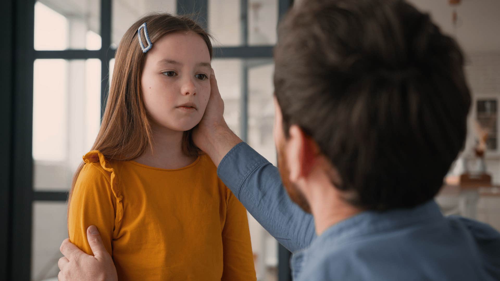 dad touching daughter's cheek saying she doesn't have to apologize