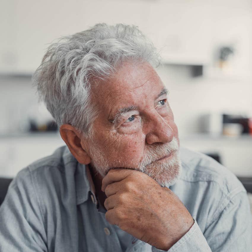 older man thinking while sitting on couch at home