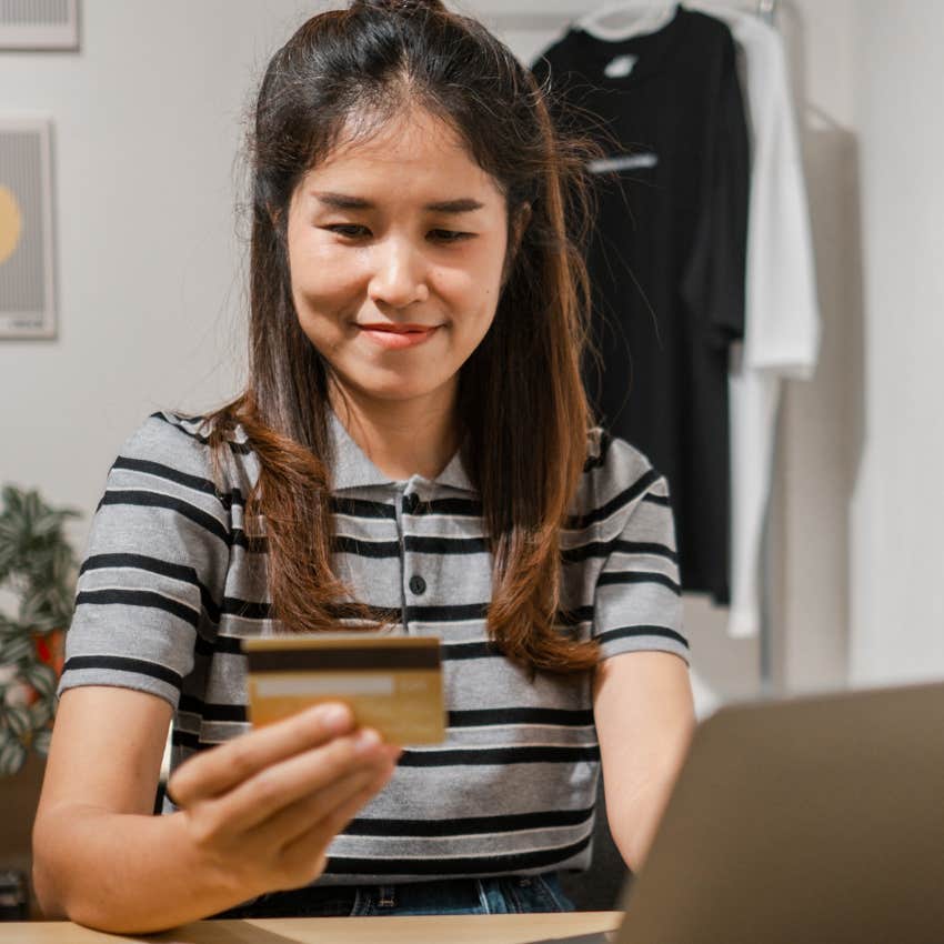 young woman buying into trends and materialism using her credit card
