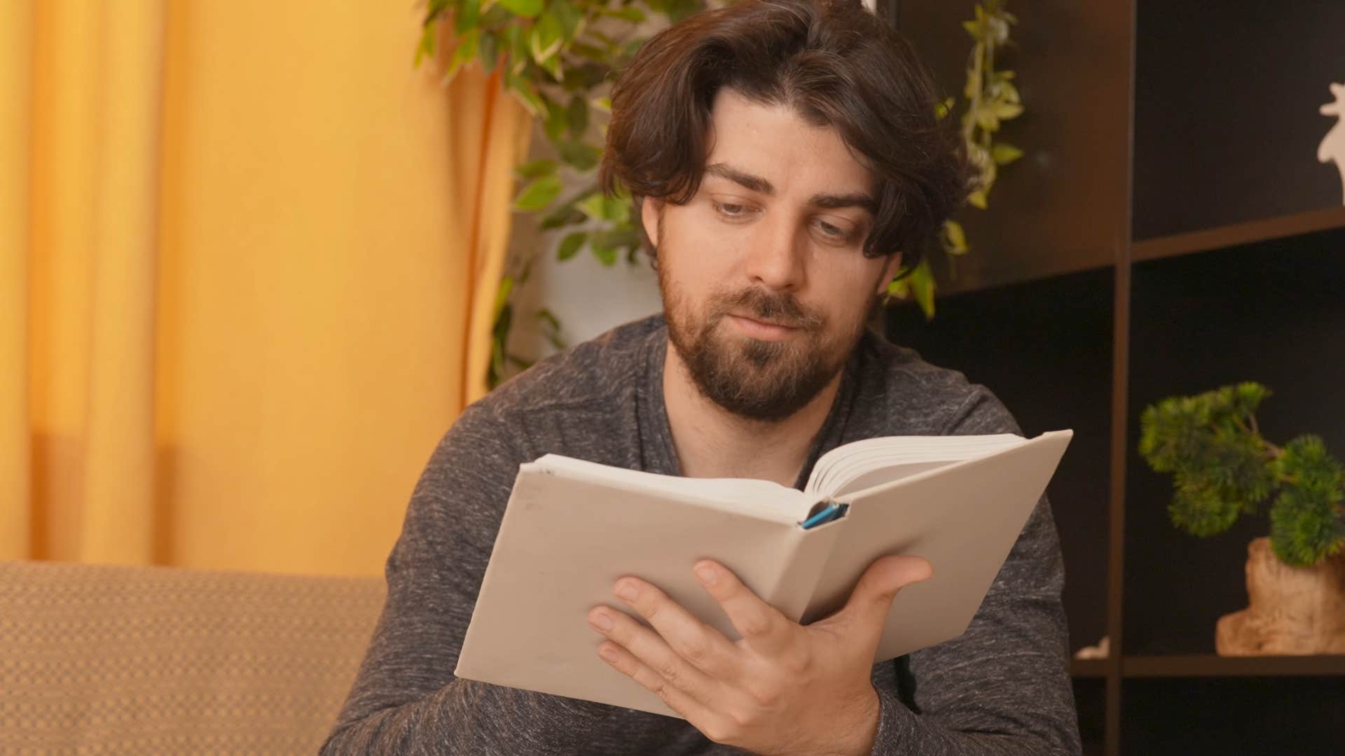 Man raised in the 80s dealing with boredom reading a book at home