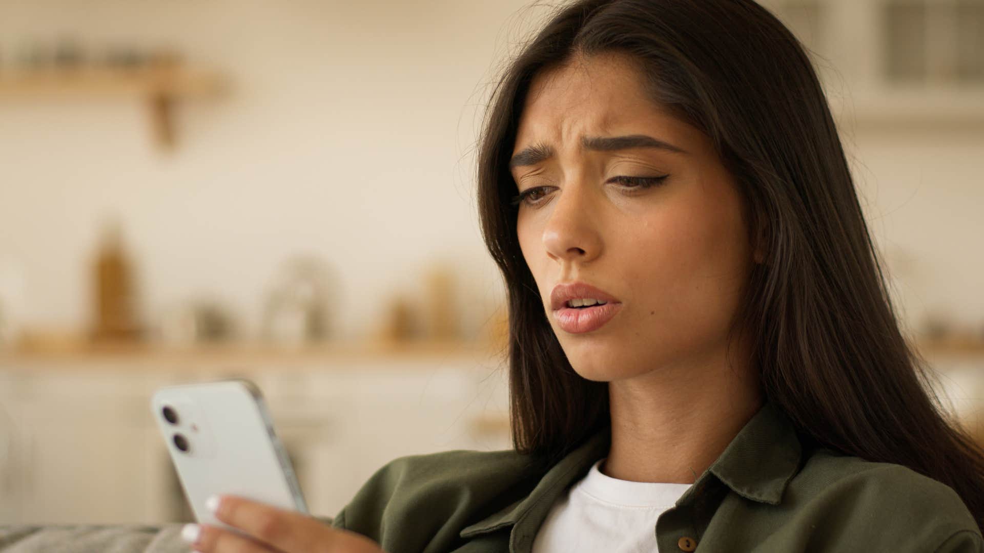 Woman with a fear of missing out looking at her phone.
