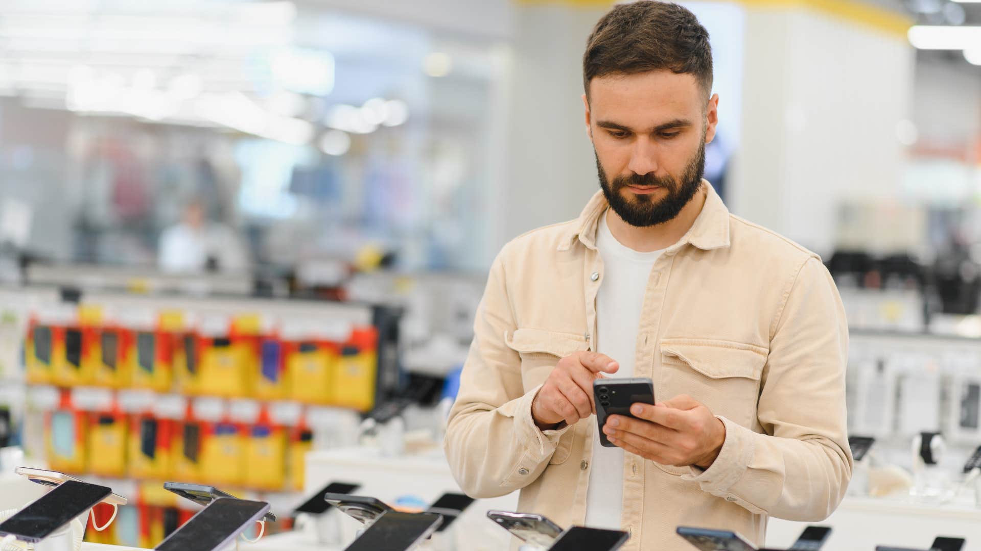 Man trying to find the next best thing while shopping for a phone.