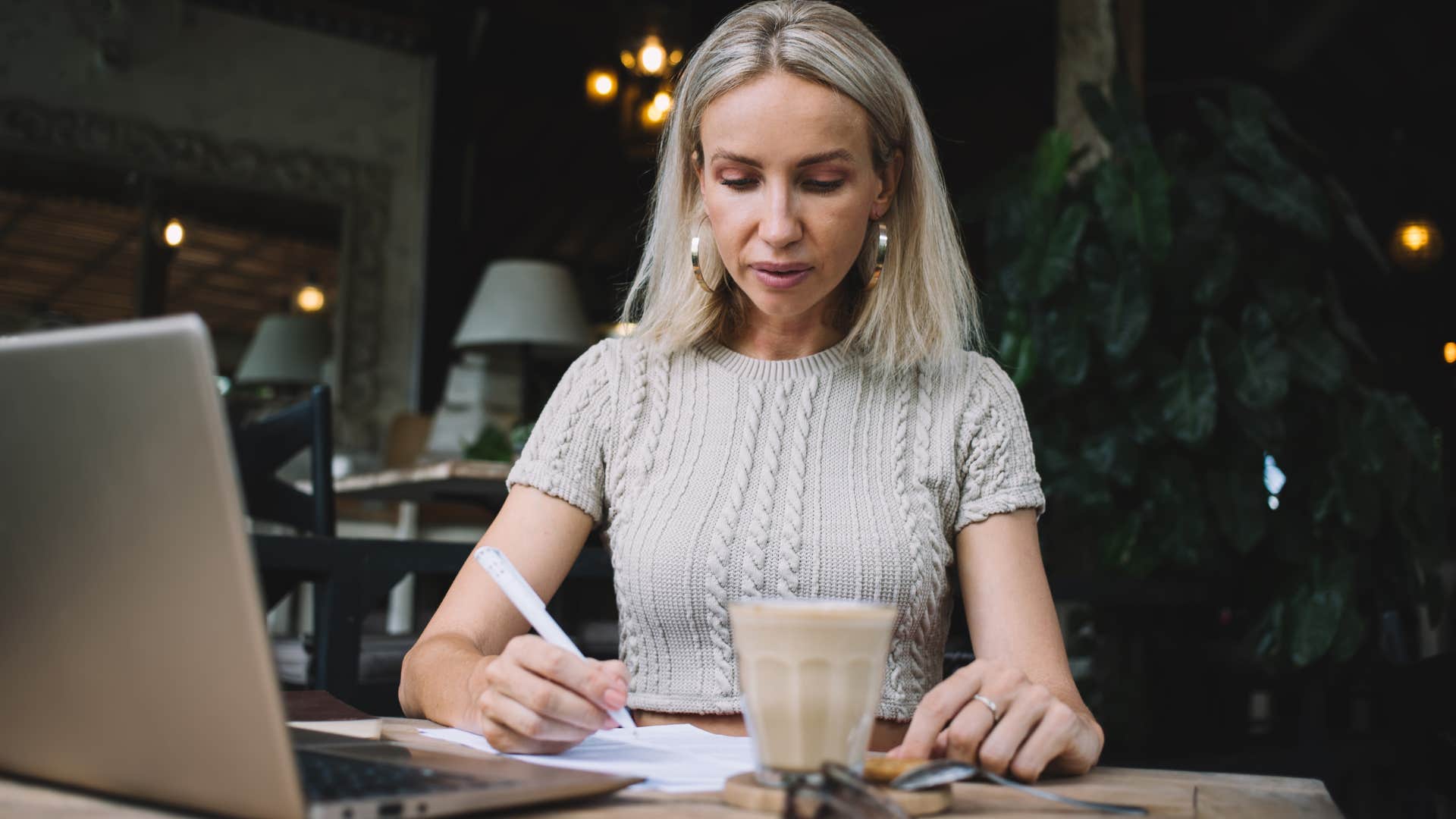 Gen X woman addressing and sending letters at a coffee shop