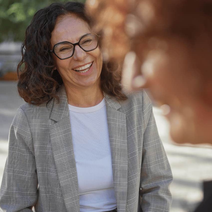 Woman who can talk to anyone smiling with a stranger