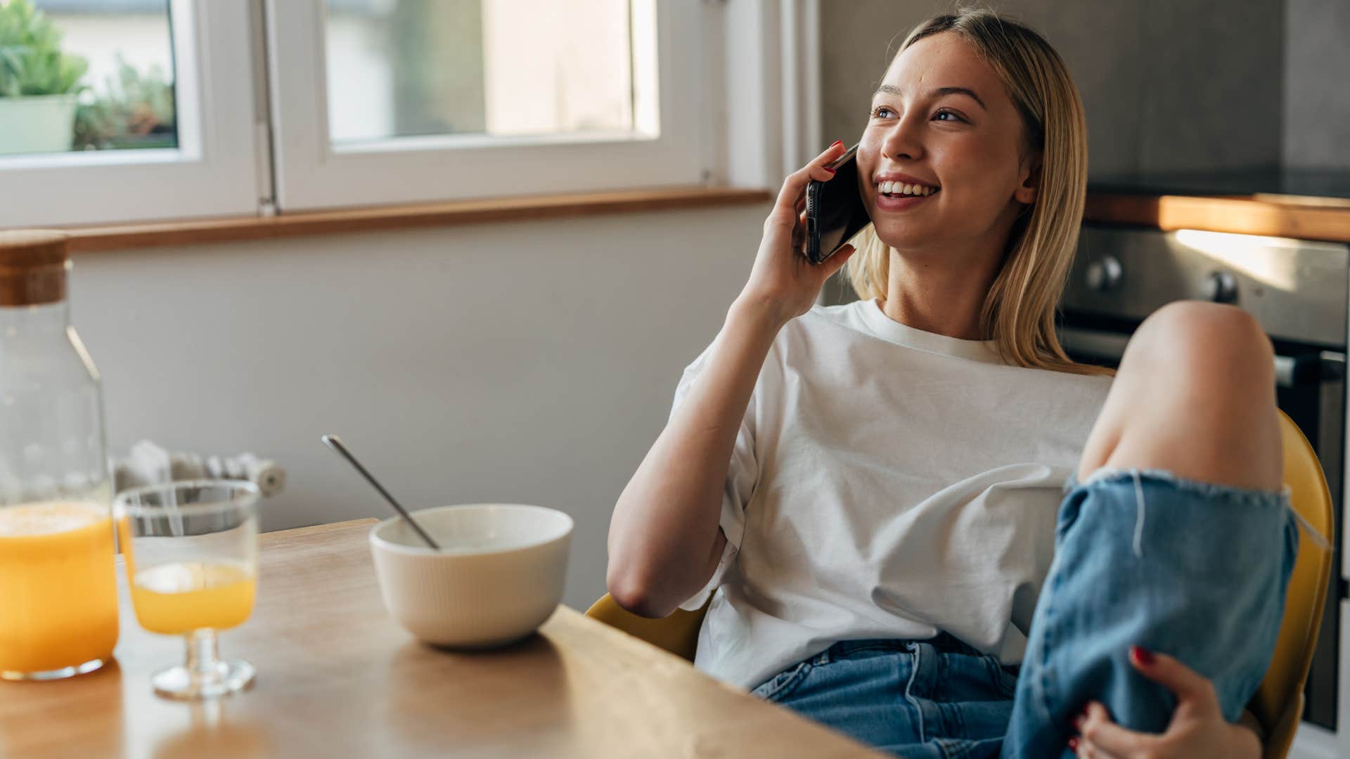 woman talking on phone sitting at table