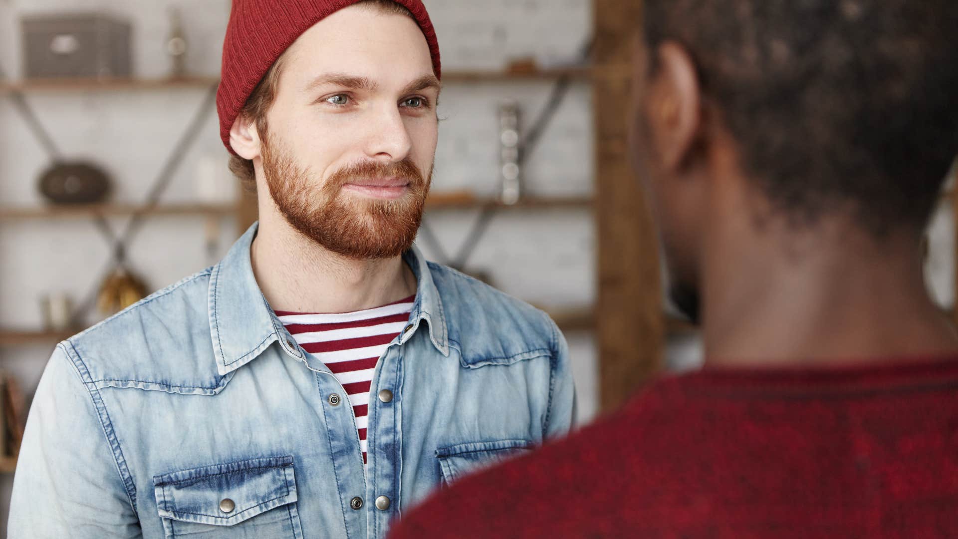 man looking and listening to friend speak