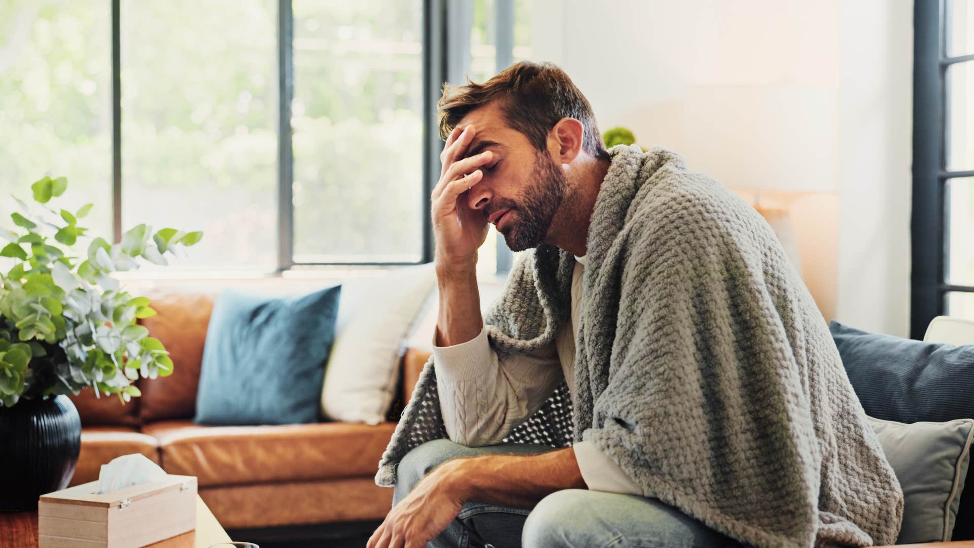 depressed man sitting at home alone canceling plans