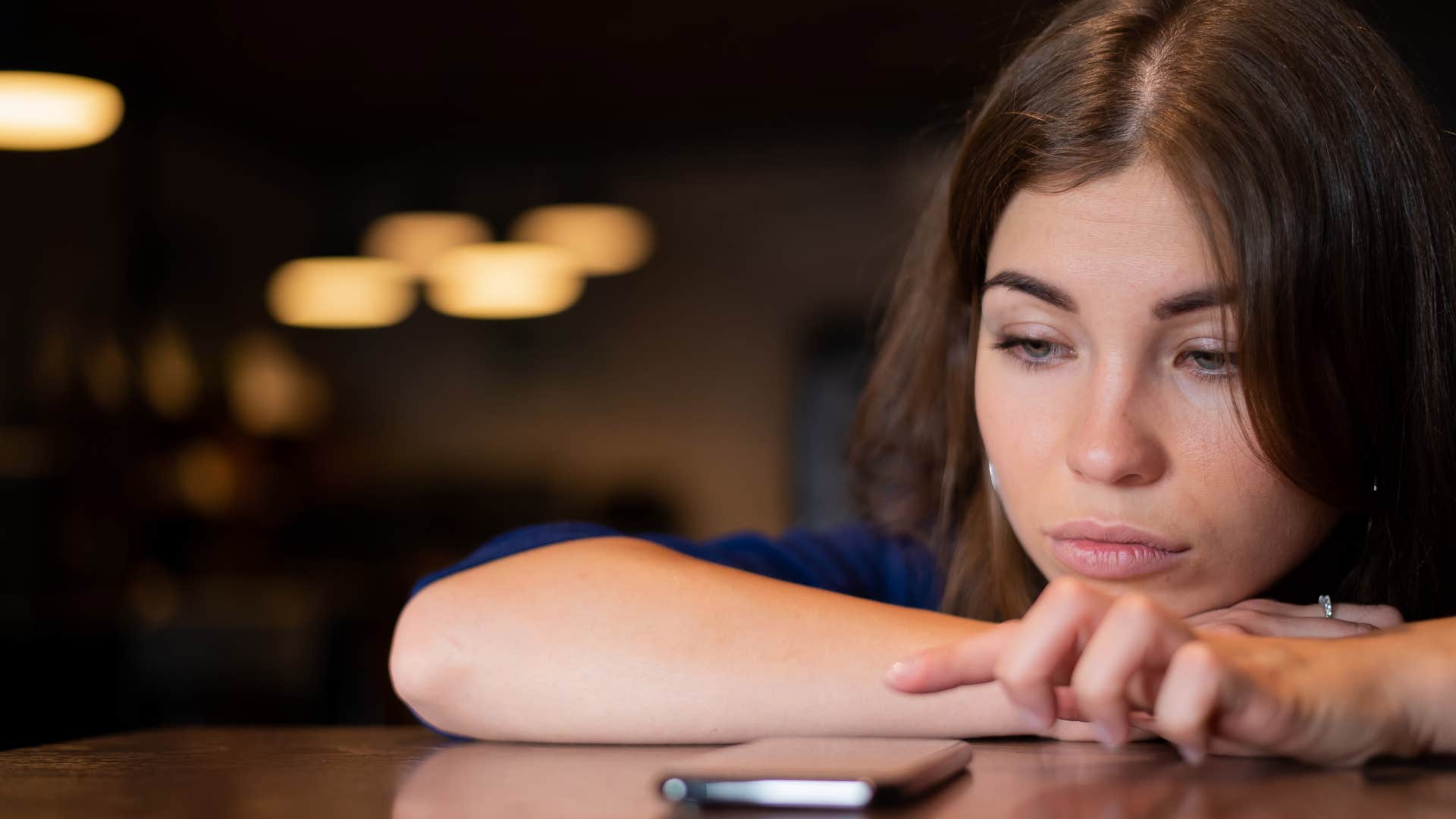 woman looking at phone ignoring text messages
