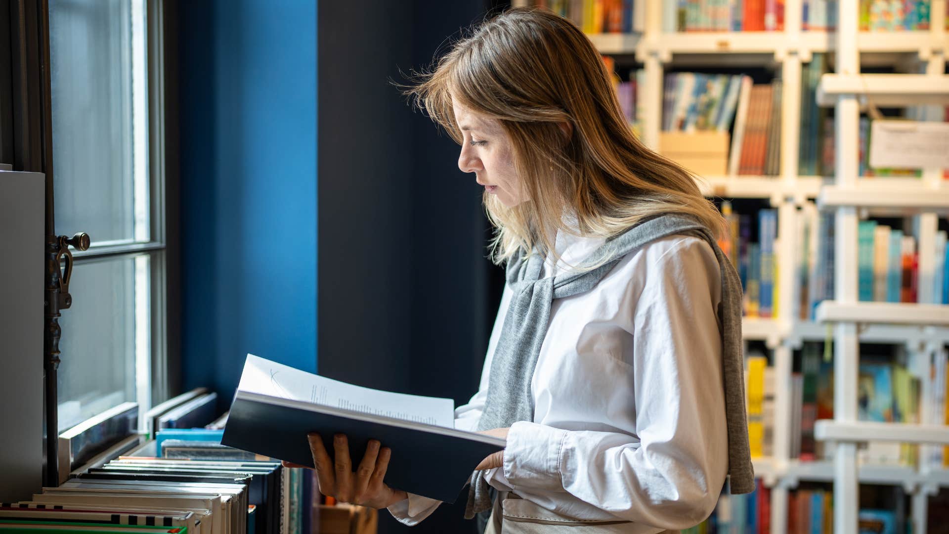 woman focused on reading a book in the library