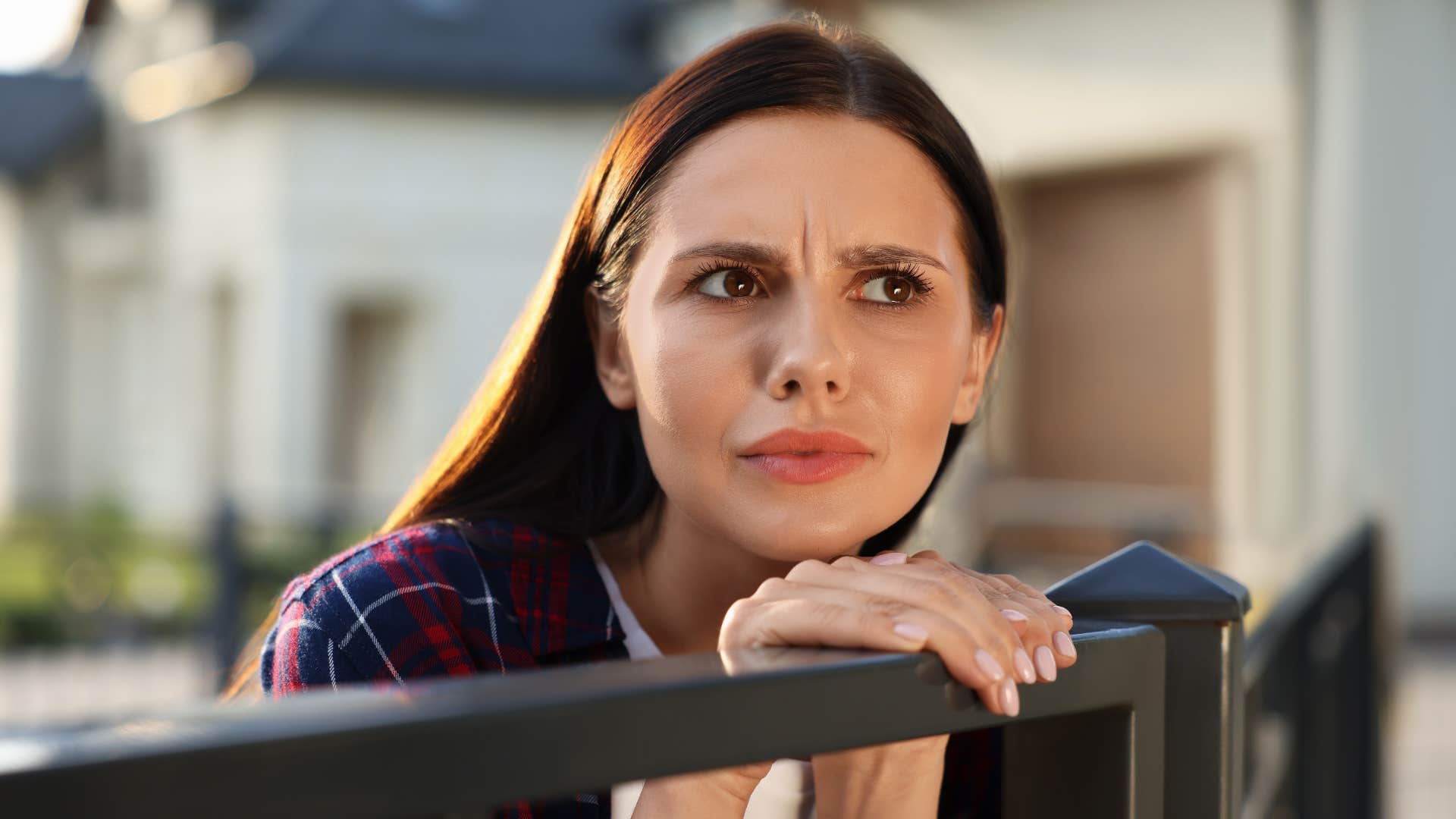 suspicious woman who is hiding something standing outside