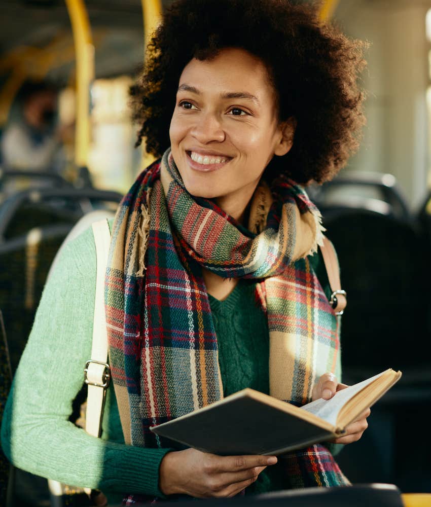 happy person reads book on bus showing creative habit
