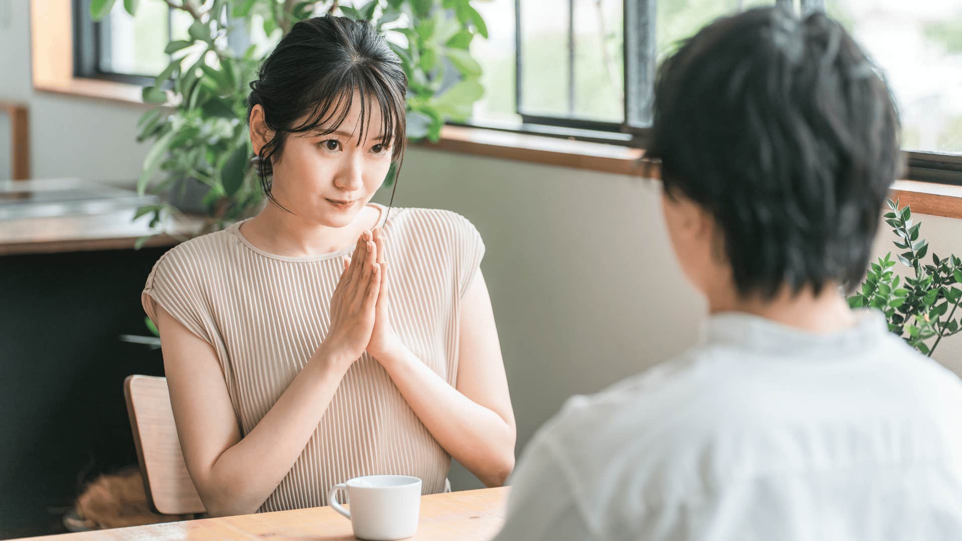 awkward woman telling friend sorry for saying that in uncomfortable conversation