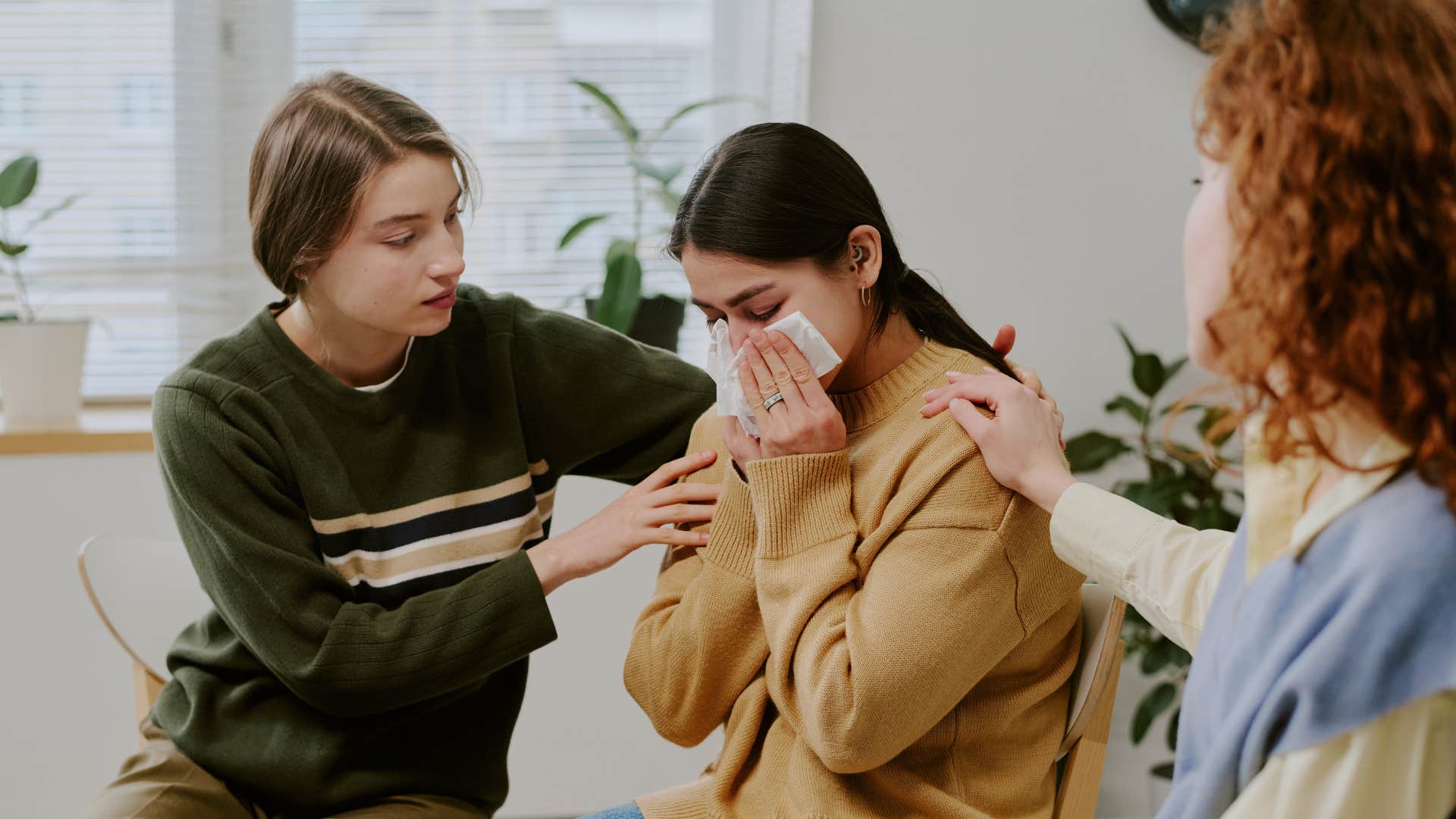 friends comforting crying friend apologizing saying that wasn't fair to you at all